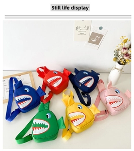 Flat lay of colorful cartoon shark chest bags for kids in six vibrant nylon colors