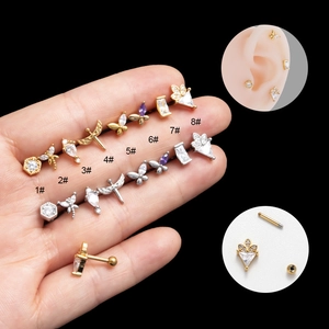 Close-up of gold and silver butterfly cartilage piercings with cubic zirconia studs