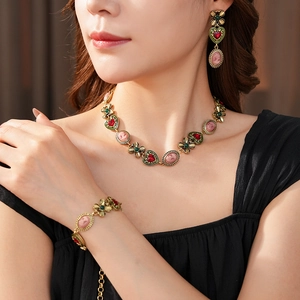 Parure de bijoux vintage avec gemmes cœurs rouges et camées roses portés par un mannequin