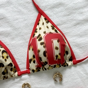 Close-up of leopard bikini top with red number 10 print and red halter neck straps