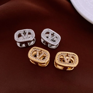 Detail of 18k gold plated oval earrings with V-logo and sparkling cubic zirconia stones