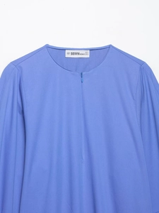 Détail du col d'une chemise en popeline bleue avec fermeture éclair et texture tissée