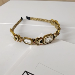 Detailed view of the golden woven headband with crystals and baroque pearls decoration