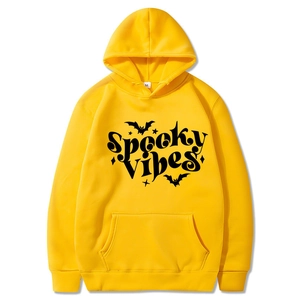 Detail of Spooky Vibes text and bat print on a yellow Halloween hooded sweatshirt