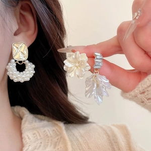 Primo piano dettagliato di cerchi di perle e borchie di cristallo floreali indossati da modella