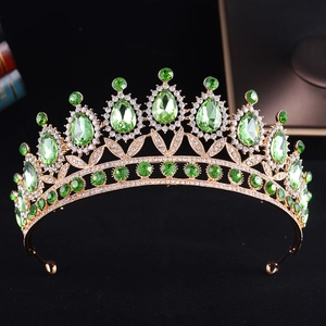 Macro detail of gold bridal crown featuring teardrop green crystals and sparkling rhinestones