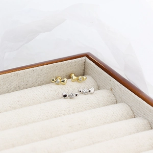Close-up of gold and silver S925 heart earrings with small diamonds in a jewelry box