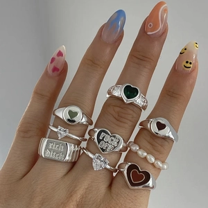 Double-layered silver heart rings with crystals and enamel shown on hand model