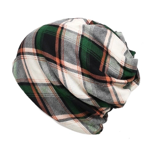 Close-up of green and orange plaid knit pattern on a soft thermal beanie hat