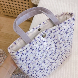 Détail du sac à lunch en coton floral avec motifs violets et bouton-pression en métal