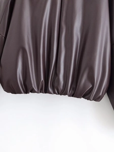 Détail de l'ourlet de veste en cuir marron foncé avec bord élastique et coutures précises