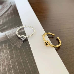 Detail of gold and silver bamboo rings with black zircon cross patterns on a white book