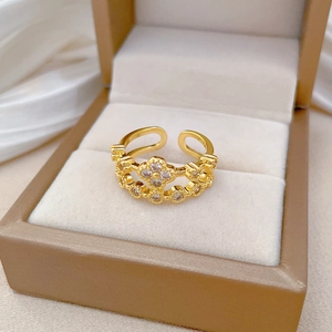 Close-up of gold clover ring with pavé crystals and adjustable band in jewelry box