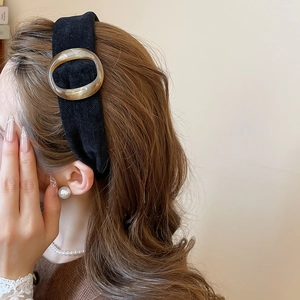 Dettaglio del cerchietto in tessuto vintage con fibbia in resina tartarugata su modella