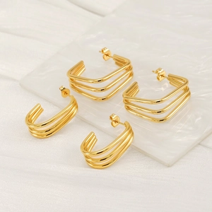 Triple-line gold plated stainless steel C-shaped hoop earrings for women on white surface