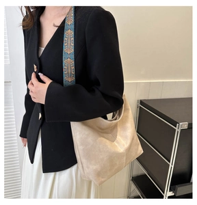 Detail view of large beige tote bag with a colorful bohemian woven wide shoulder strap