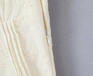 Detailed view of cream lace dress with floral embroidery and invisible side zipper