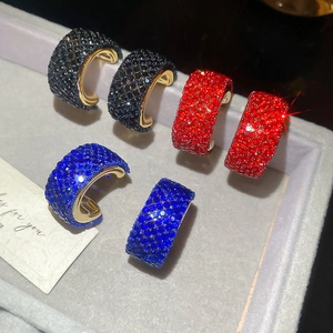 Detailed view of wide C-shaped crystal earrings in black, red and royal blue colors