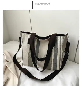 Detail of grey vertical striped canvas tote bag with brown straps for commuting