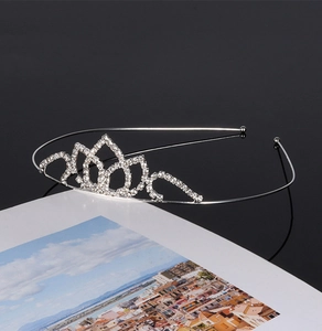 Detailed close-up of a silver bridal crown with sparkling rhinestones on a flat surface