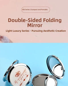 Detail of round metal folding double-sided makeup mirror with white leather crown design