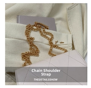 Detail of light beige quilted crossbody bag with light gold metal chain strap