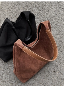 Detailed texture of brown and black suede tote bags with smooth leather straps