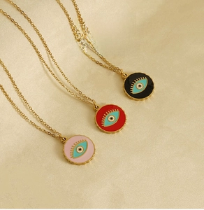 Detail of three 18K gold plated stainless steel necklaces with enamel evil eye pendants