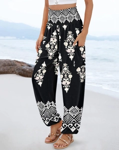 Detail of high-waisted bohemian print trousers with side pockets on a beach backdrop