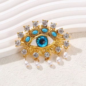 Evil eye brooch with gold plating, blue stones, white zircons and hanging pearls