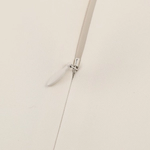 Close-up of invisible zipper detail on high-quality cream-colored puff sleeve top