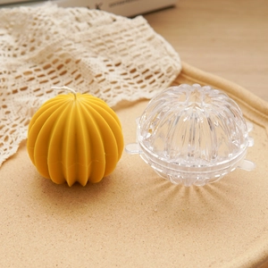 Spherical ribbed acrylic mold for DIY scented candles with yellow grooved candle sample