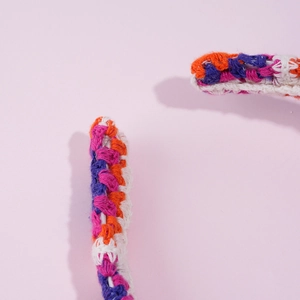 Close-up of handmade floral crochet headband with colorful knit patterns and texture