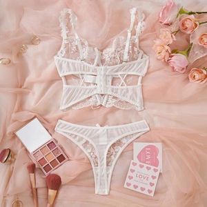 Detailed flat lay of a white lace lingerie set with mesh details and multi-strap design