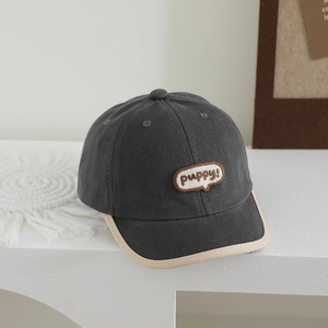 Detail of dark grey kids baseball cap featuring puppy embroidery and beige contrast brim