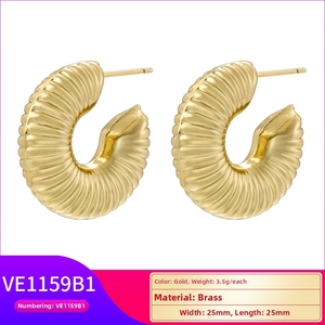Detail of C-shaped hollow heart earrings with twisted texture in brass gold finish