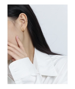 Close-up of a gold S925 sterling silver olive bead ear cuff worn by a model