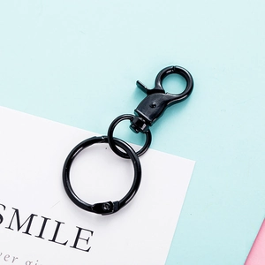 Detail showing a black metal lobster clasp and keyring on a decorative card