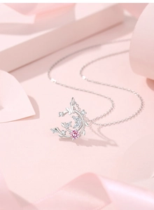 Macro shot of silver vine and butterfly pendant necklace with pink zircon and white gems