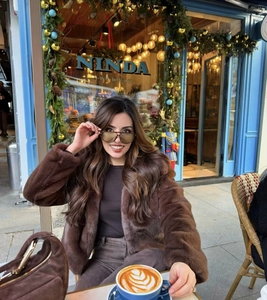 Brown faux fur jacket featuring a large collar shown in an outdoor lifestyle setting