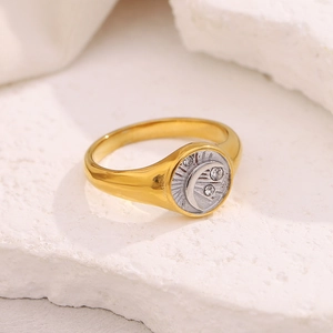 Detailed macro view of 18K gold plated moon ring with white crystals on stone texture