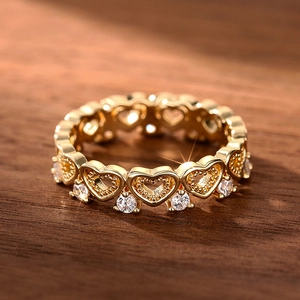 Macro detail of gold-tone heart ring with pavé cubic zirconia and milgrain edge