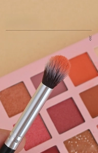 Vue macro du pinceau maquillage flamme avec poils doux orange dégradé pour estomper