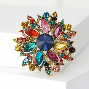 Detail of vintage colorful floral brooch with vibrant crystals on an antique gold base