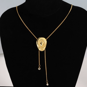 Detail of a gold-tone bolo necklace featuring a textured oval slide on a black bust