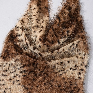 Détail de tissu en fausse fourrure léopard avec de longues franges et des tons dorés