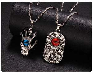 Dettaglio di collane d'argento con mano di Hamsa occhio blu e ciondolo rettangolare occhio rosso