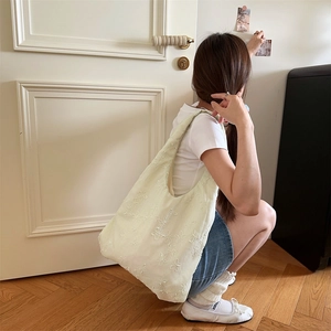 Detail einer hellgelben bestickten Chiffon-Tasche getragen von einem Modell im weichen Licht