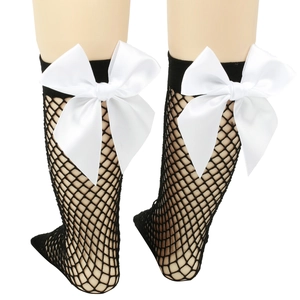 Detail of girls black fishnet knee-high socks with a large white satin bow decoration