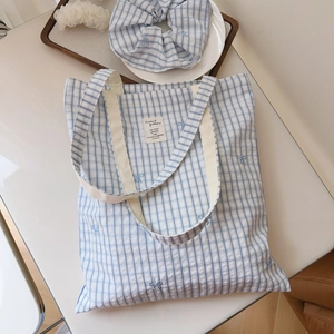 Detail of blue plaid cotton tote bag with bow embroidery and matching hair scrunchie